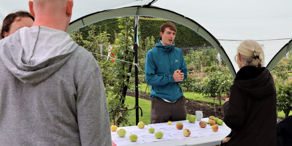 Max Brown, a bioinformatician on the DToL project, talks apples with visitors to Harvest Festival visitors